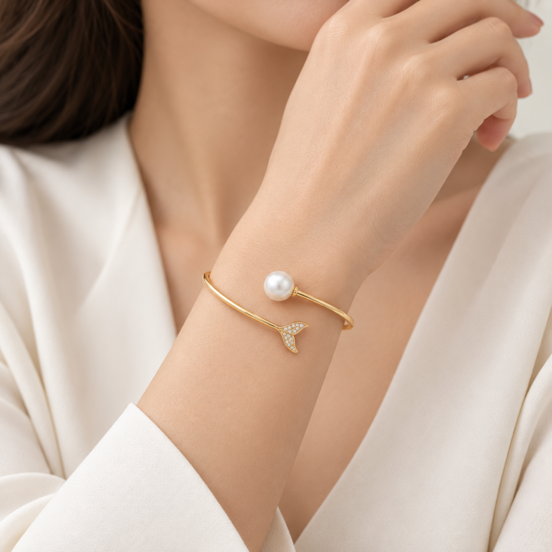 aramis-gold-pearl-bracelet-on-wrist.jpg دستبند طلای آرامیس با مروارید و جزئیات برلیان روی مچ دست